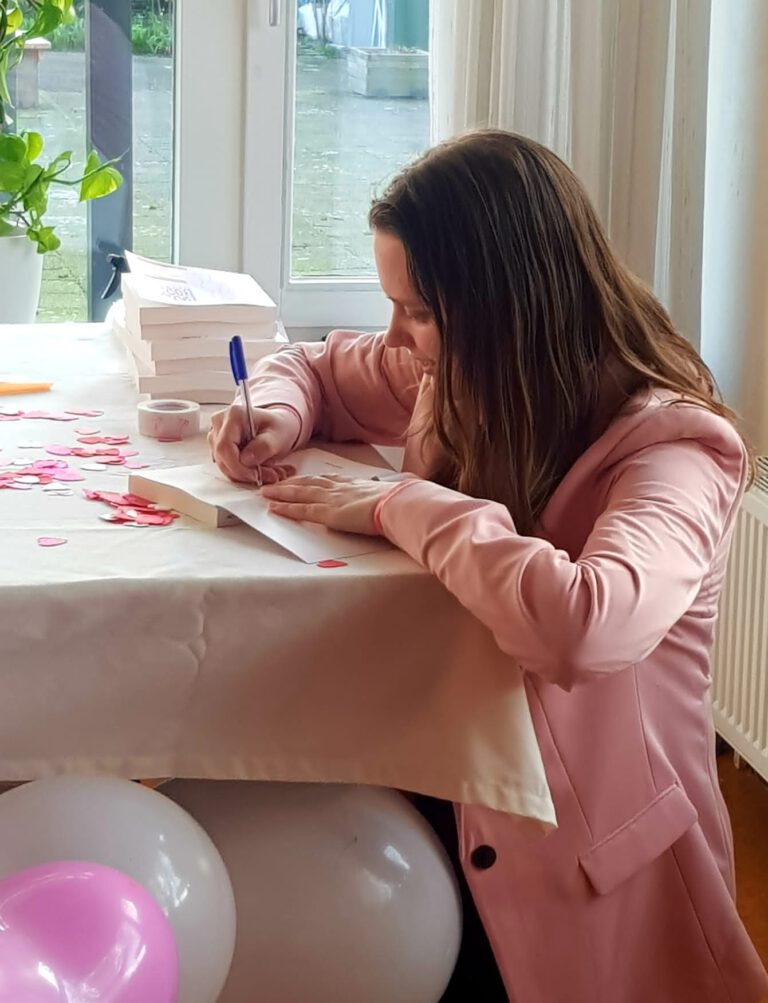 Quinty emilie zet een handtekening in haar boek